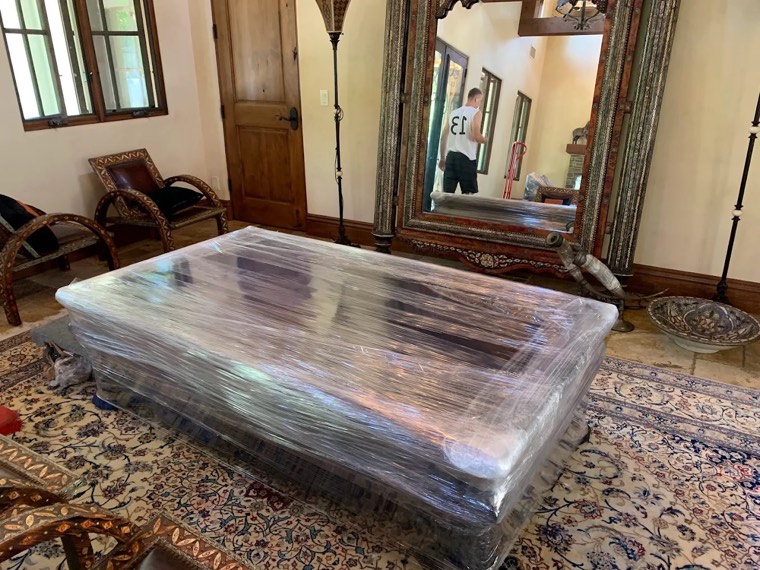 Large antique furniture carefully wrapped in protective plastic by Happy Home Moovers