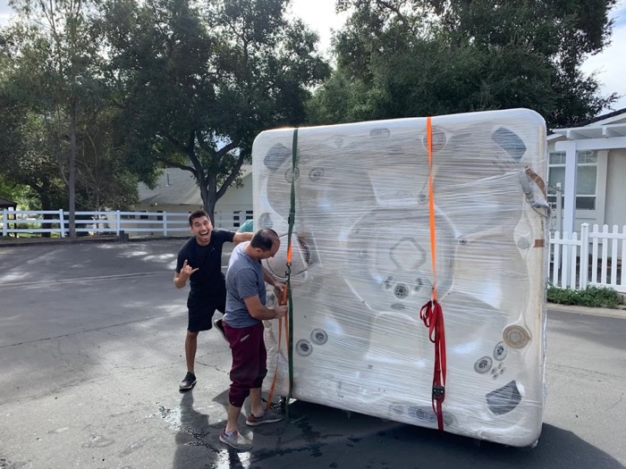 Happy Home Moovers crew securing a wrapped hot tub for safe transport