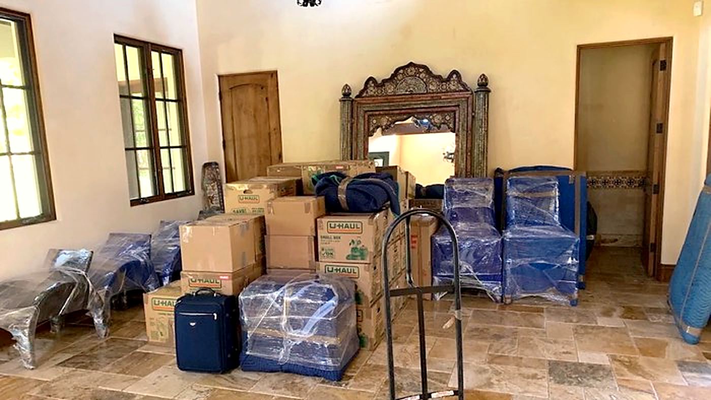 A home after a Happy Home Moovers delivery: boxes stacked and blanket-wrapped furniture set down inside
